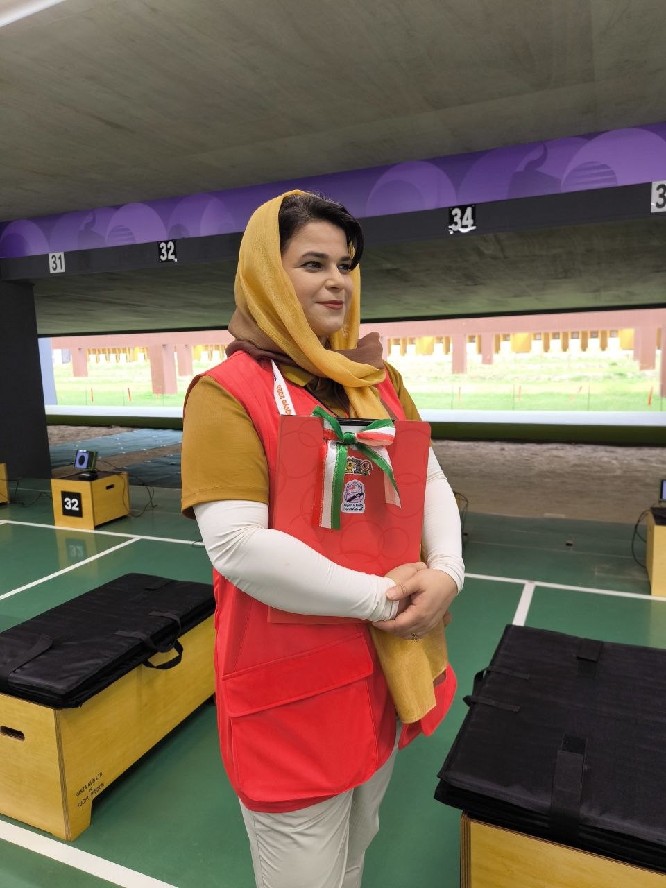 هانیه خندان، داور بینالمللی و برجسته تیراندازی کشورمان، در حاشیه برگزاری رقابتهای تیراندازی در بیستمین دوره بازیهای آسیایی ناگویا، در اقدامی توجهبرانگیز و معنادار با پرچم مقدس جمهوری اسلامی ایران و نماد یادبود کودکان میناب در سالن مسابقات حاضر شد.